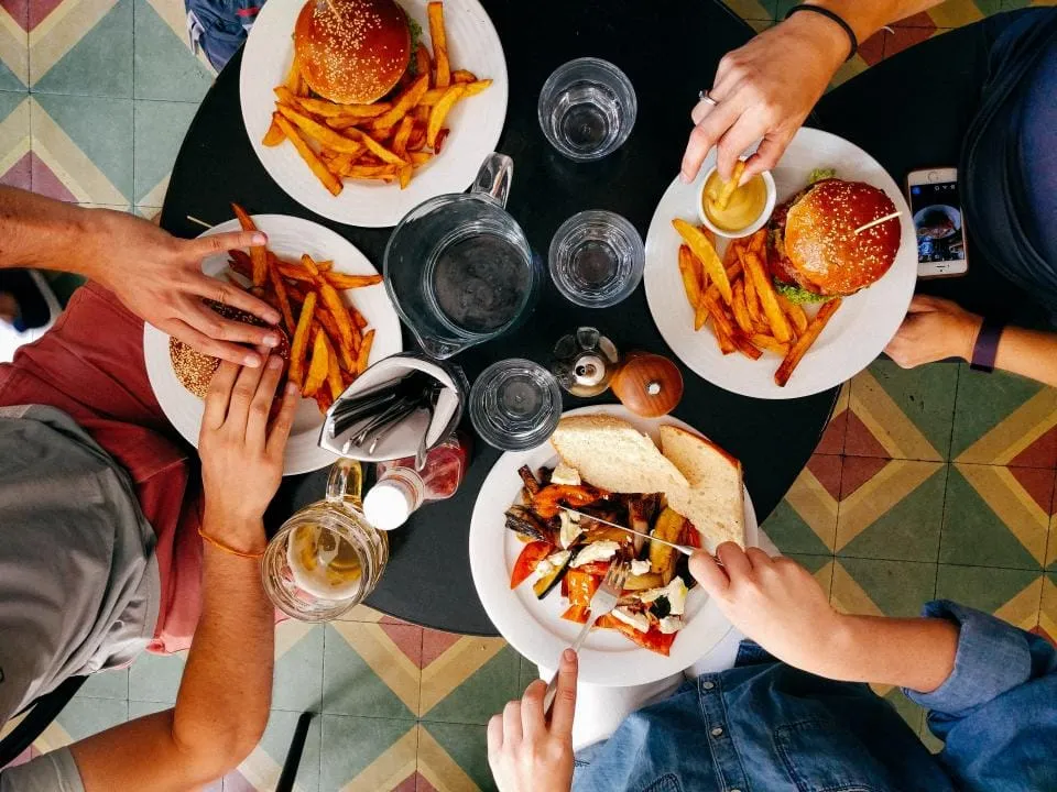 Amigos compartiendo platos en una mesa